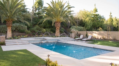 Outdoor pool with attached spa and lounge chairs Photo