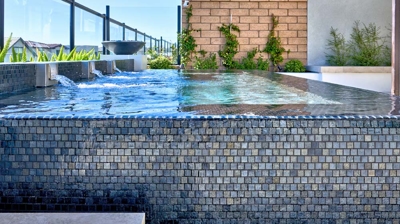 Elevated spa sanctuary nestled beside a inviting fire pit and vibrant potted greenery. Photo