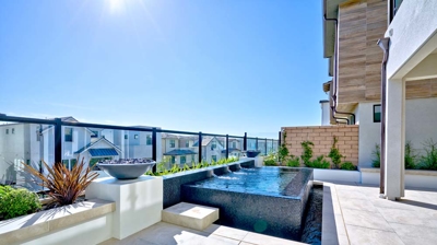 Sunlit rooftop retreat featuring a spa. Photo