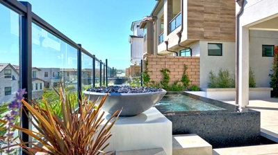 A rooftop spa next to a fire pit and potted plants. Photo