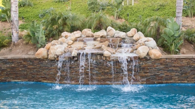 Backyard pool with rock fountain Photo