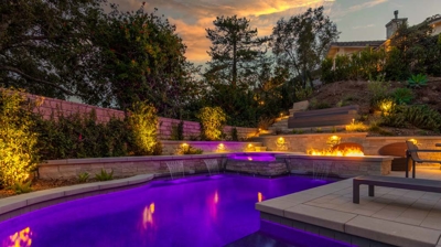 Backyard pool at night with purple pool lights Photo