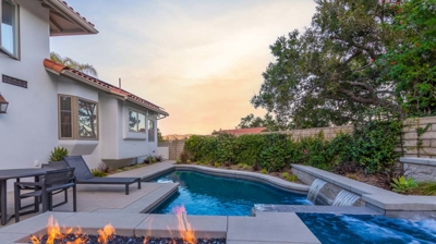 Backyard fire pit next to spa and pool Photo