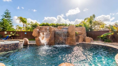 A symphony of water: curved pool, hot tub, and captivating waterfall Photo