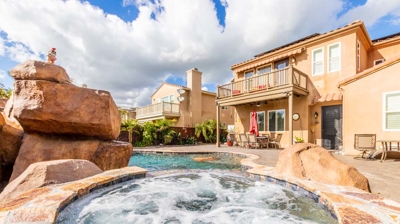 Picturesque view of a curved pool with a hot tub and cascading waterfall Photo
