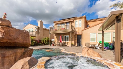 Tranquil oasis featuring a curved pool, hot tub, and mesmerizing waterfall Photo
