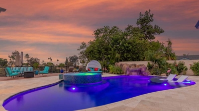 Twilight magic: oval pool and hot tub illuminated against the darkening sky Photo