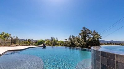 A serene pool with gracefully curved edges, glistening in the sunlight. Photo