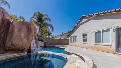 A serene retreat with a pool, hot tub, and majestic waterfall blending harmoniously Photo