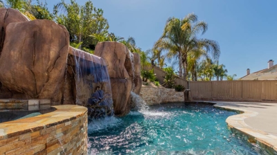 A refreshing pool and inviting hot tub with a mesmerizing waterfall backdrop Photo