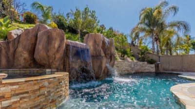 A tranquil escape featuring a pool, hot tub, and picturesque waterfall Photo