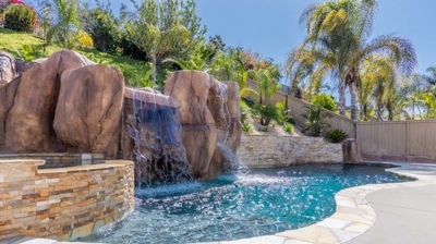 Poolside paradise complete with a hot tub and cascading waterfall Photo