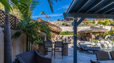 Tiki-themed outdoor seating area with comfortable chairs and palm leaf decor Photo