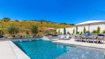 Relaxing suburban retreat with a rectangular pool bordered by hills Photo