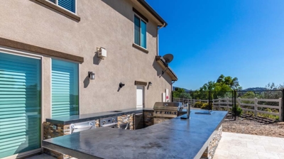 Al fresco culinary space with a well-equipped outdoor kitchen, including a grill and oven Photo