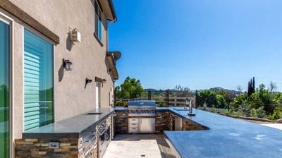 Picture of an outdoor kitchen with essential appliances such as a grill, oven, and taps Photo