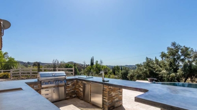 Enticing outdoor culinary setup with a grill, oven, and taps for a complete kitchen experience Photo