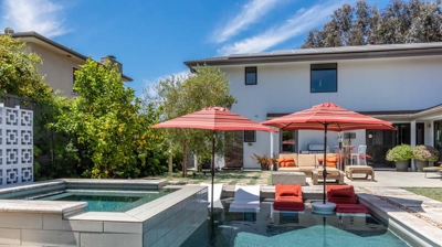 Scenic view of a rectangular pool and hot tub in a lush suburban backyard Photo