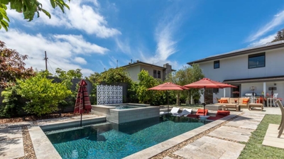 Tranquil suburban landscape featuring a rectangular pool and hot tub Photo