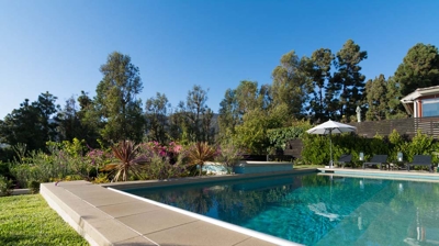 Inviting suburban escape: rectangular pool and hot tub surrounded by greenery Photo