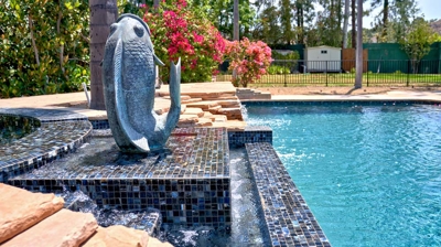 Side view of a rocky pool wall with waterfall Photo