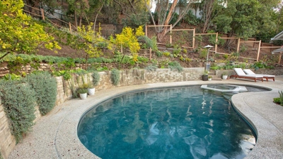 Side view of pool in backyard with landscaping and plants Photo