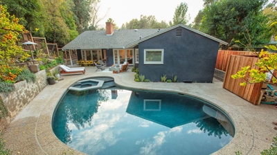 Back view of curvy pool in backyard Photo