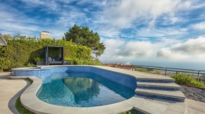Blue sky with clouds above a curvy pool with big cement steps on the side Photo