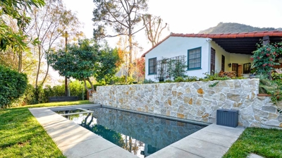 A pathway surrounds a pool in a backyard Photo