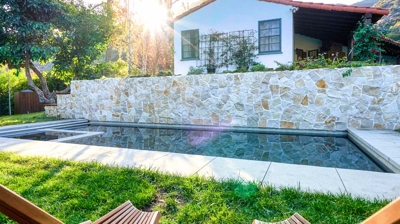 Chairs directed at a pool with a house in the background Photo