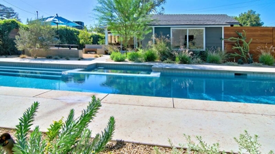 A pool surrounded by a cement path Photo