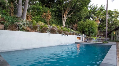 Relaxing suburban escape: rectangular pool bordered by vibrant plants and trees Photo