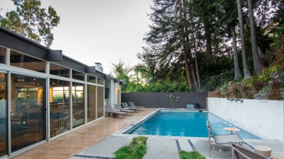 Tranquil oasis: rectangular pool in a lush suburban backyard providing relaxation and rejuvenation Photo