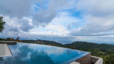 Elevated relaxation: infinity pool and hot tub offering panoramic mountain views Photo