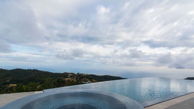 Infinity pool and hot tub providing a tranquil retreat amidst verdant mountains Photo