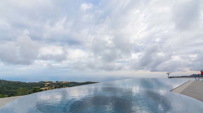 Infinity pool and hot tub offering stunning views of lush mountains Photo