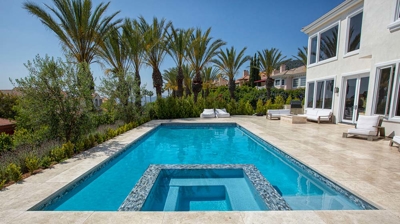 Outdoor built in pool surrounded by palm trees Photo