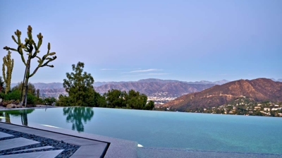 Infinity pool with a mountain view at sunset Photo