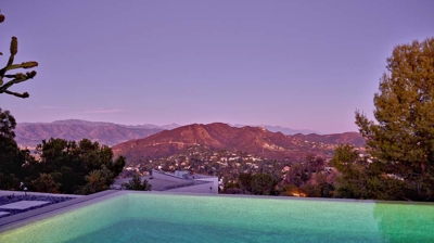 Infinity pool with a mountain view at sunset Photo