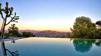 Infinity pool with a mountain view at sunset Photo