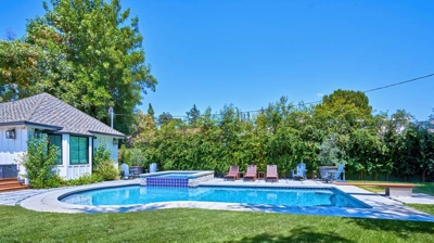 Built in pool surrounded by grass and lounge area Photo