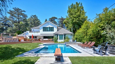 Backyard pool with view of diving board and house Photo