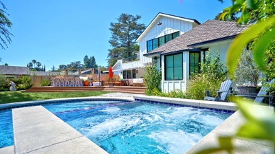 Backyard pool with view of jacuzzi with jets bubbling Photo