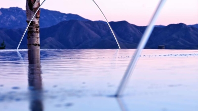 The top of a pool at sunset showing water features and ripples. Photo