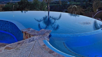 A pool and spa nestled amidst swaying palm trees. Photo