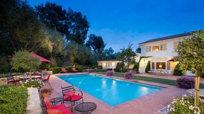 Tranquil pool surrounded by a natural stone wall and sculpted shrubbery Photo