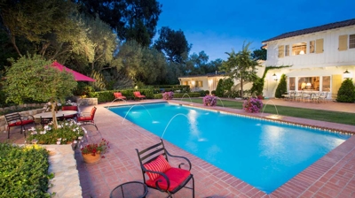Pool nestled within a natural stone wall adorned with lush greenery Photo