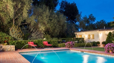 Poolside paradise with a natural stone wall and carefully shaped shrubbery Photo