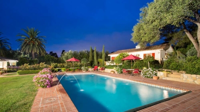 Tranquil poolside scene with elegant fountains and lush landscaping Photo