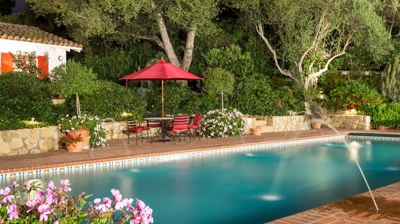 Expertly landscaped pool area with charming red brick details Photo